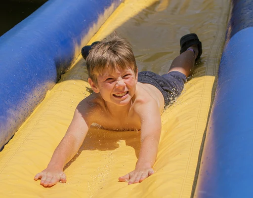 Young camper sliding down the slide